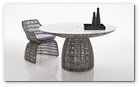 :: Pulse para Ampliar :: Presume de presencia escultórica la nueva mesa redonda, que entra a formar parte de la colección Crinoline. Coherente con esta serie, recrea las formas curvas que caracterizan los asientos y el trenzado en fibra de polietileno, disponible en dos versiones diferentes de acabado blanco-negro o bronce-negro. La base se compone de dos elementos unidos que crean una forma de copa que sostienen los tableros, realizados en cristal de color blanco en pasta o en estratificado HPL blanco con fresado de ranuras dispuesto radialmente. Esta última versión está preparada para alojar en el centro una sombrilla.