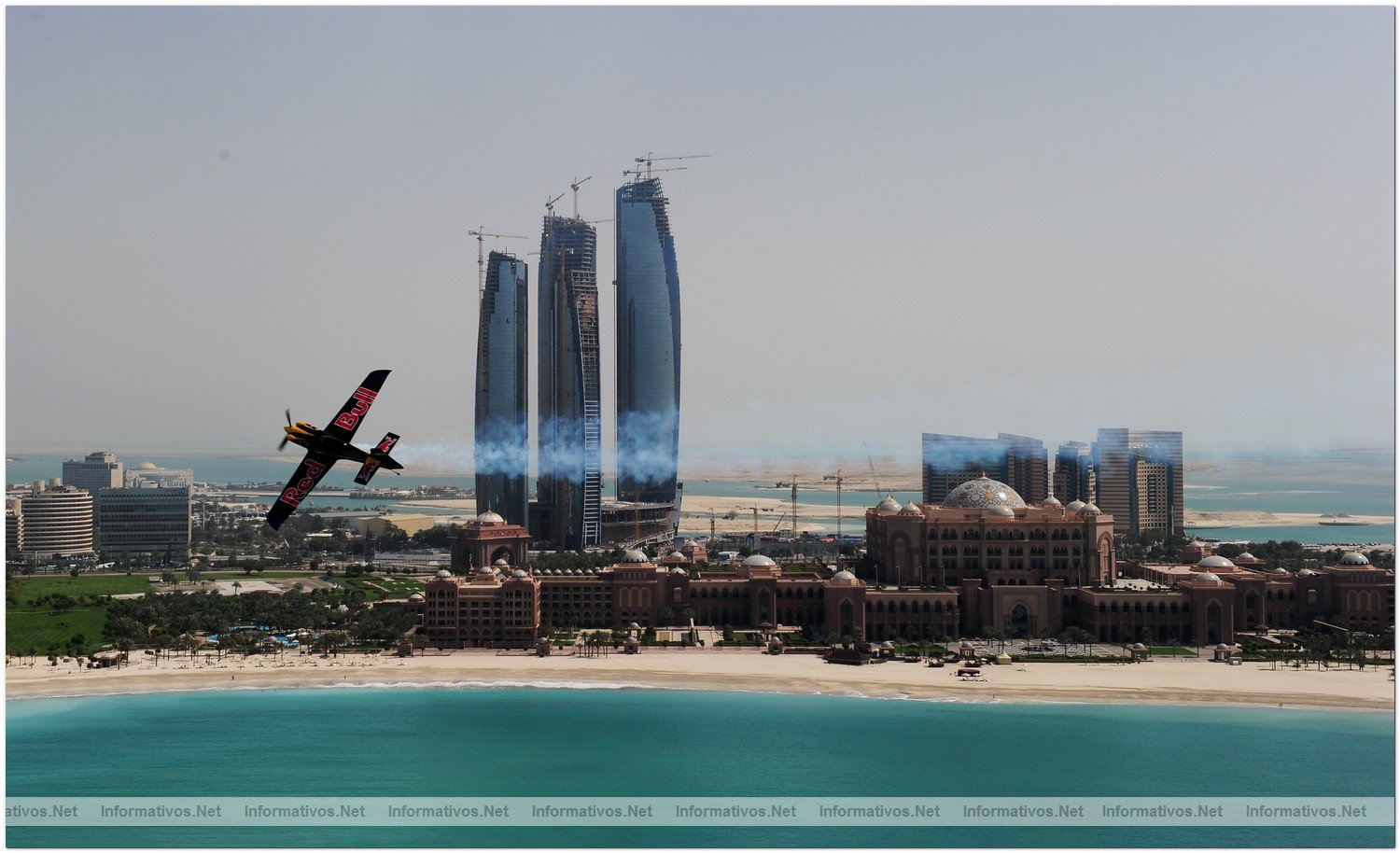 Peter Besenyei of Hungary soars above the Emirates Palace hotel and the Etihad Towers during the Abu Dhabi Red Bull Air Race fly in and Calibration day on March 23, 2010 in Abu Dhabi, United Arab Emirates