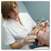 :: Pulse para Ampliar :: BCN24JUL012.- Tratamiento de Estimulación del colágeno facial en la consulta de la Dra. Nuria Espaulella. Aplicación de una crema anestésica de uso tópico