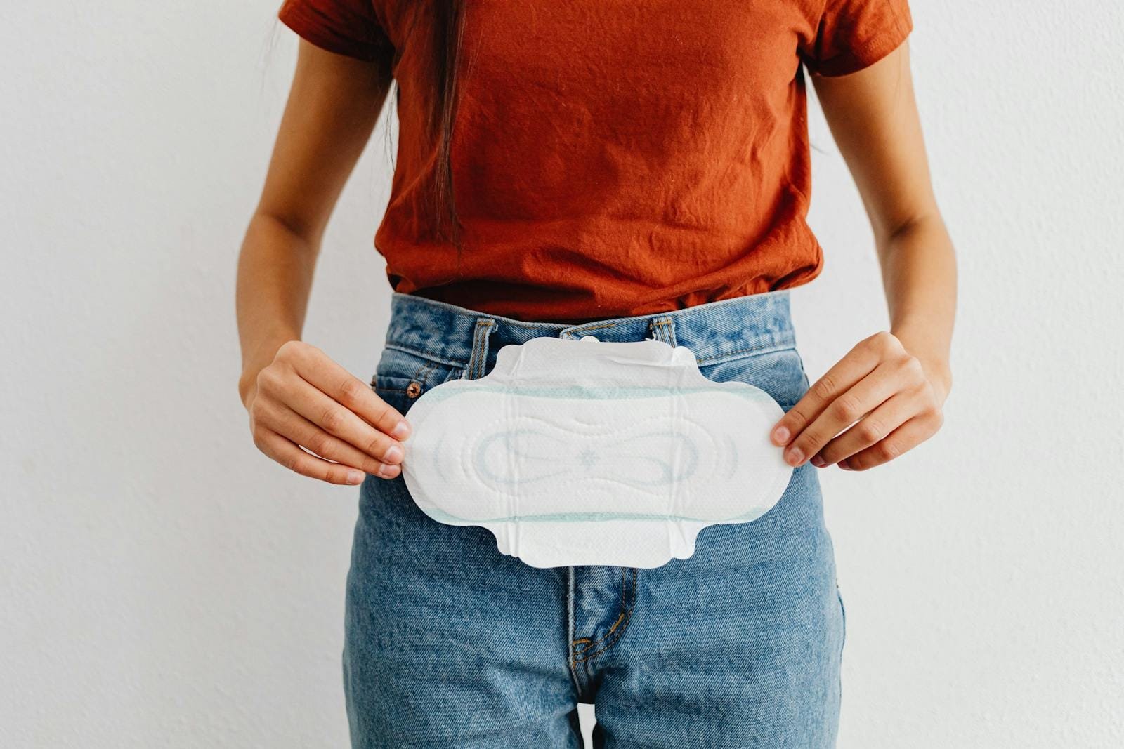 A woman showing a sanitary pad, highlighting menstrual health and hygiene.