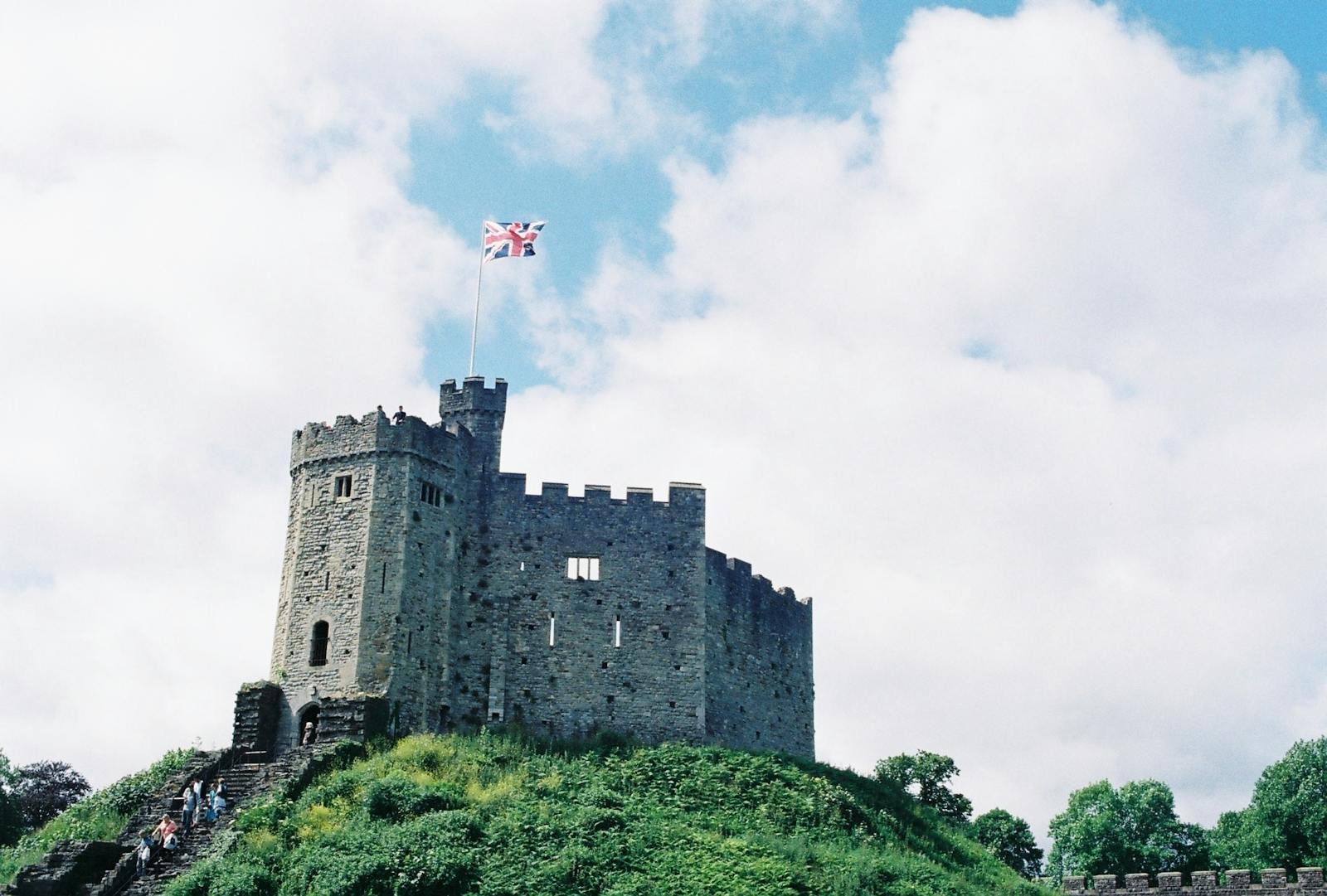 View of a historic stone castle in Scotland with the British flag flying.