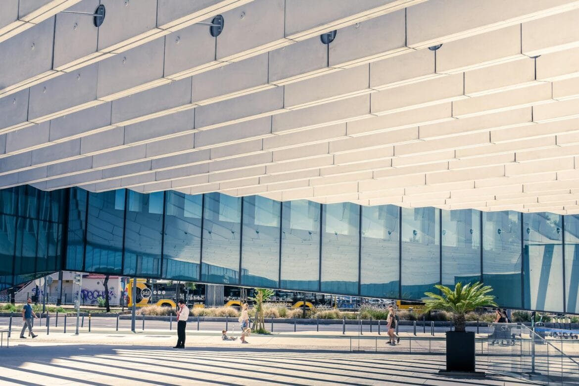 Contemporary urban architecture in Lisboa, showcasing reflections and human interaction.