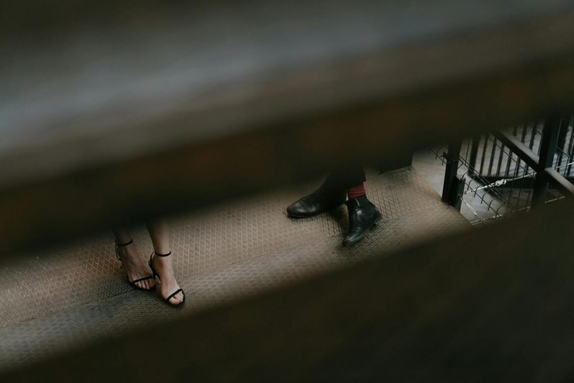 A candid shot capturing a man's and woman's feet on urban stairs with a moody vibe.