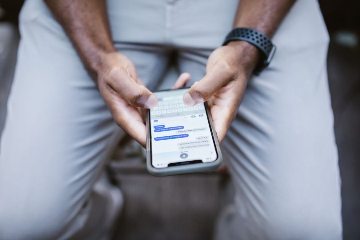 Close-up view of a man texting on a smartphone, capturing communication in action.
